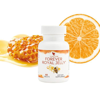 halbierte orange, honigwabe und davor plastikdose mit royal jelly
